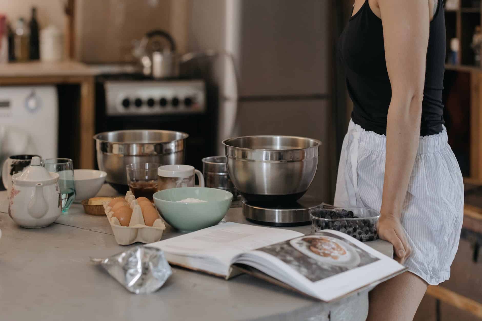 Woman In Black Shirt Standing In Front Of Table With Bowls